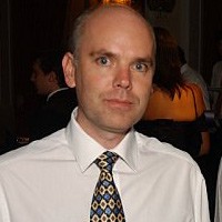 Oliver Lee Serious balding man